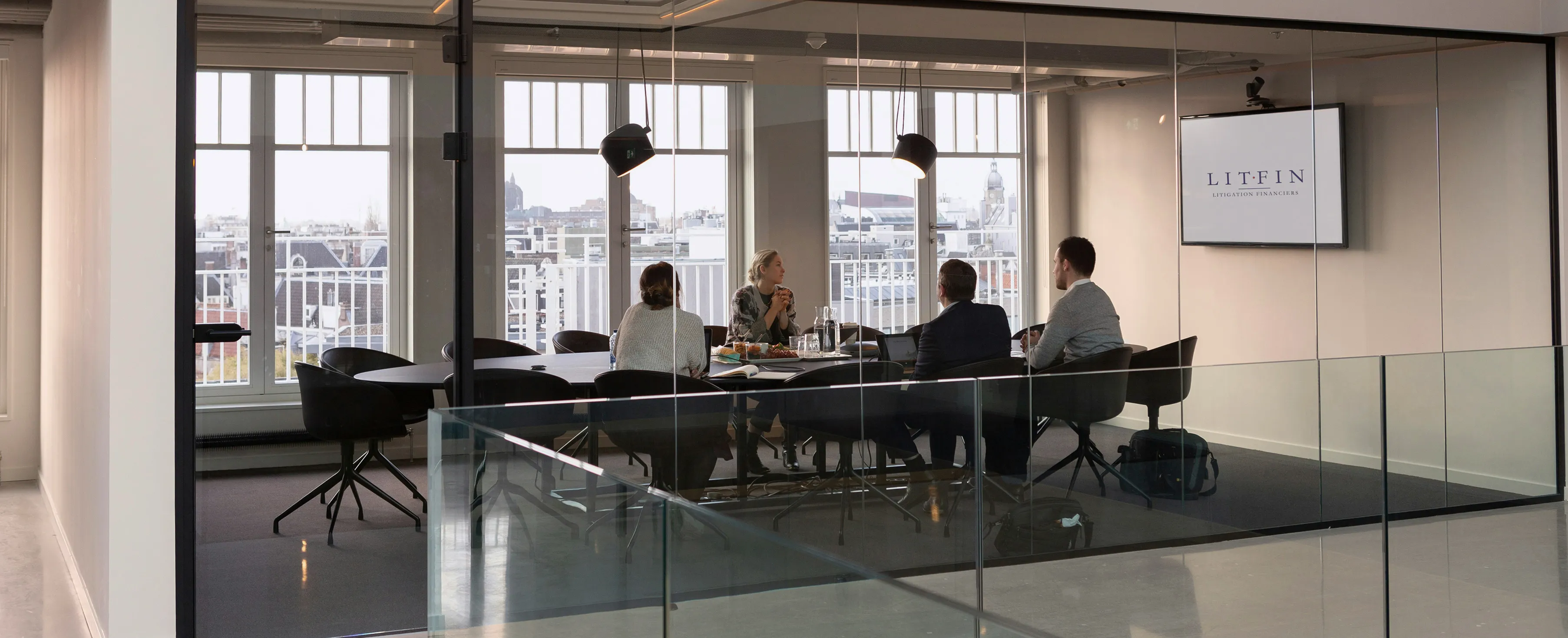 Group of four people sitting in a conference room
